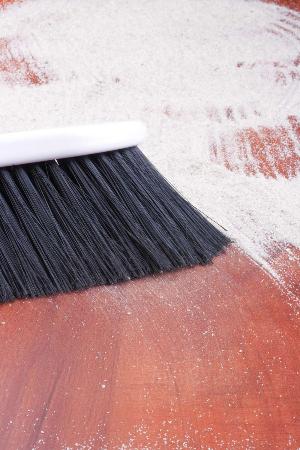 To remove stubborn adhesive from a concrete floor, cover it overnight with a thin layer of sand. Sweep the sand away just before scraping off the adhesive. 